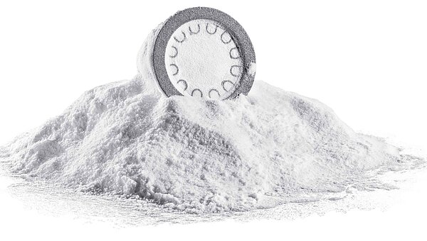 Ein weisses, ungereinigtes 3D-DruckBauteil, das auf einem Häufchen 3D-Druckpulver liegt