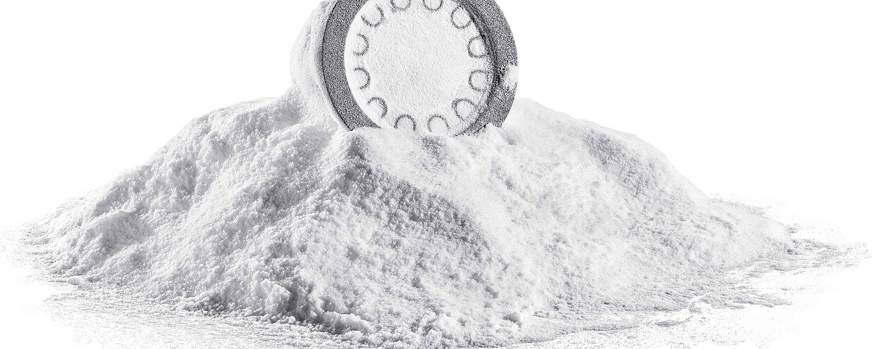Ein weisses, ungereinigtes 3D-DruckBauteil, das auf einem Häufchen 3D-Druckpulver liegt