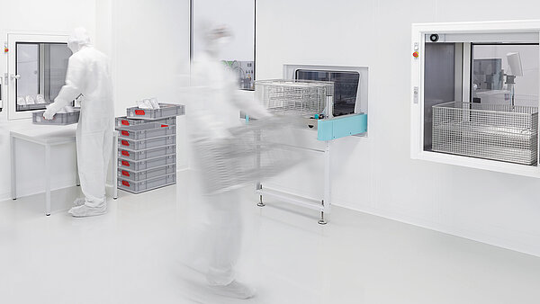 Reinigungssituation in einem Reinraum, im Hintergrund Transfersystem MAFAC Continuo