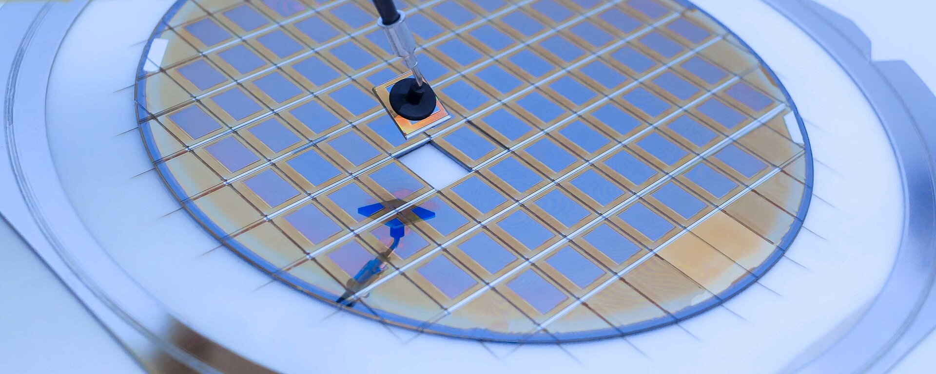 Bildausschnitt in der ein elektronischer Mikrochip mit Pinzette in einen Wafer eingebaut wird