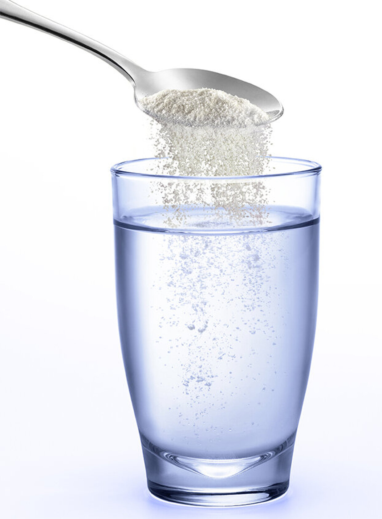 Ein Glas Wasser in das Pulver von einem Löffel einrieselt