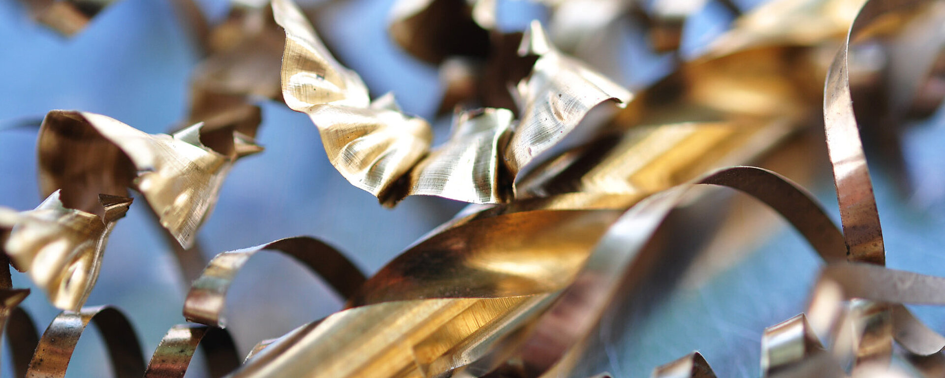 Messingfarbene Metallspäne auf blauem Hintergrund