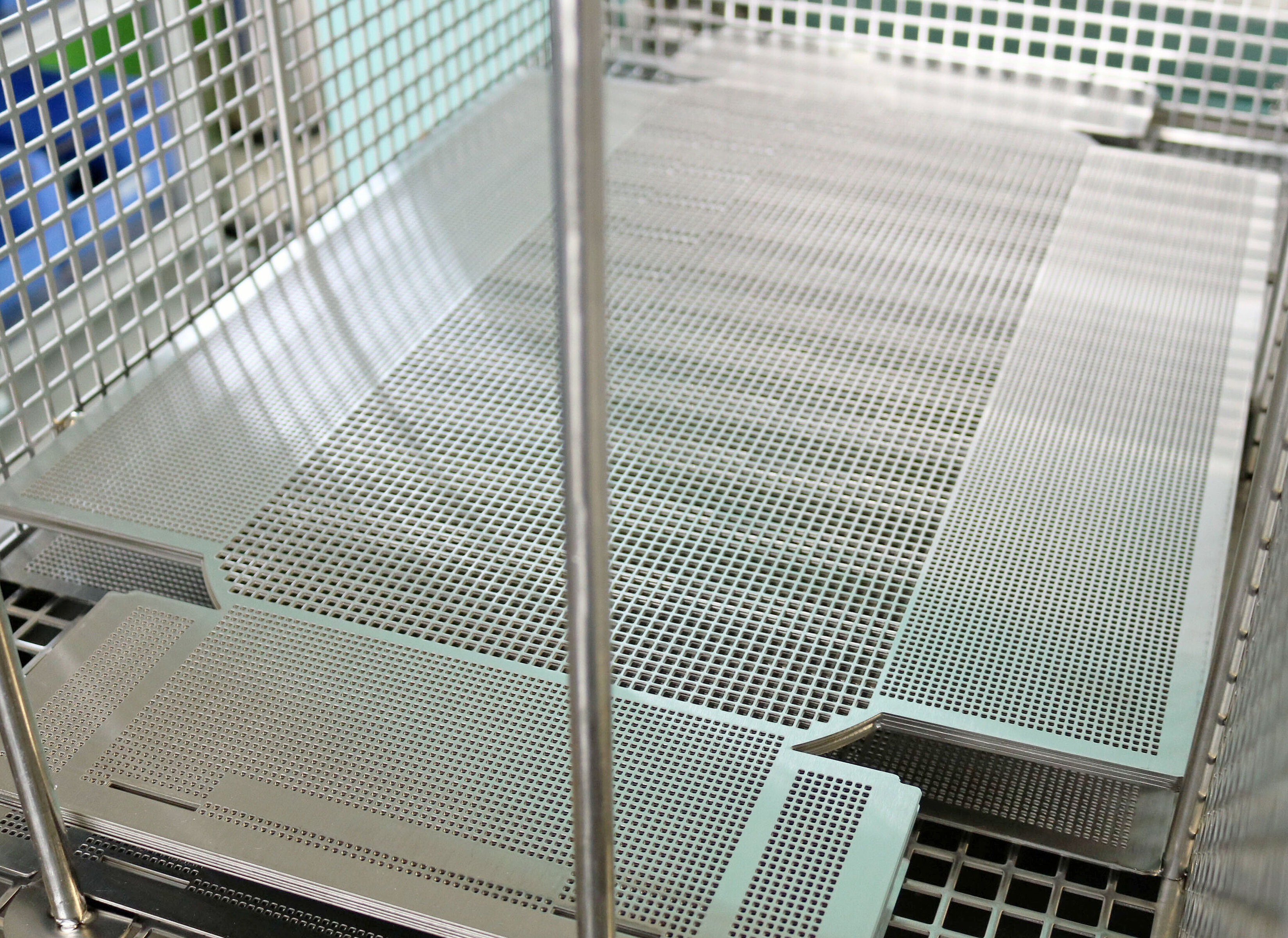 MAFAC MBE Edelstahlplatinen Metallgitter und -platten in einem industriellen Reinigungsbehälter.