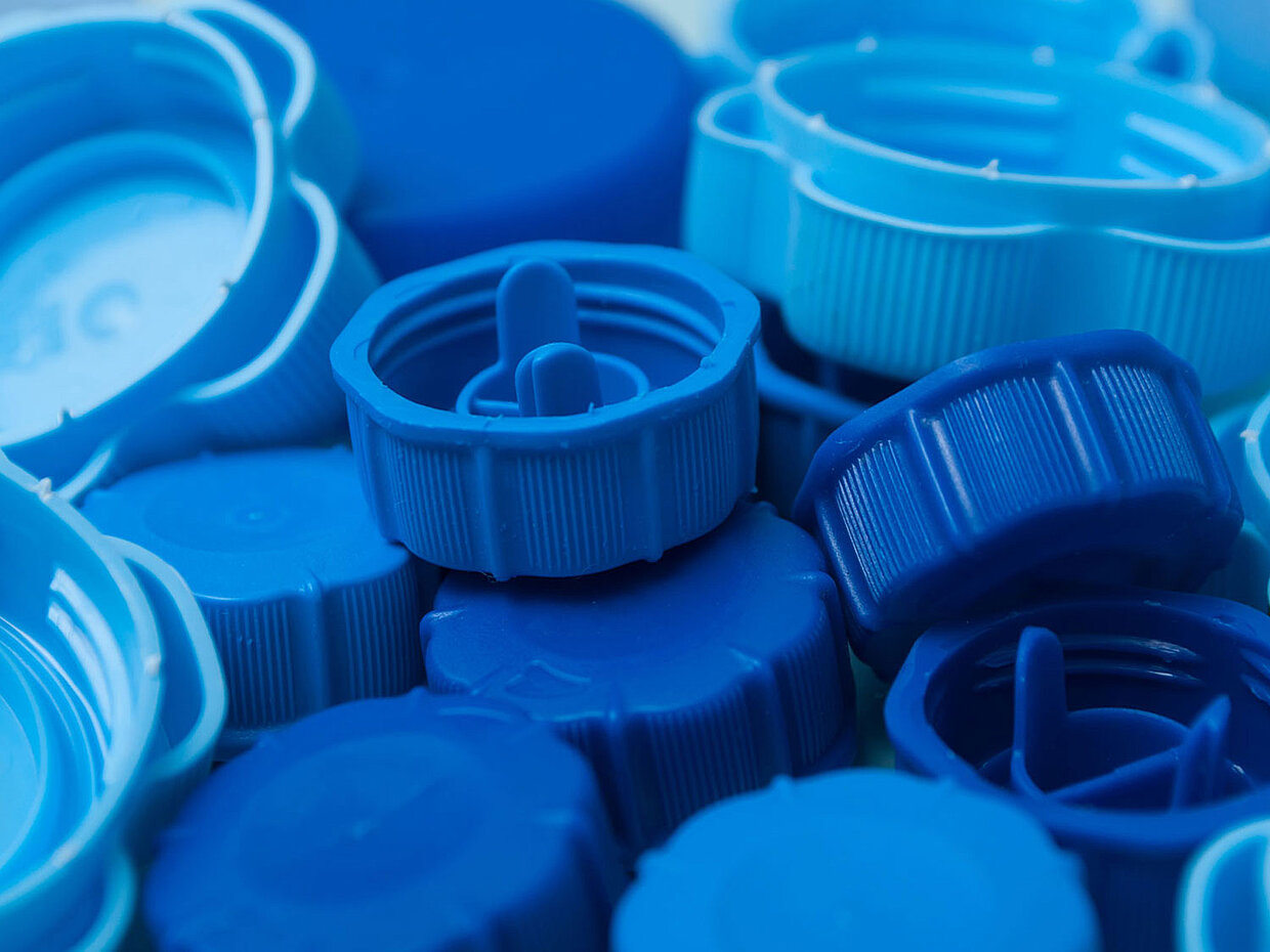 View of a loose collection of blue beverage bottle caps
