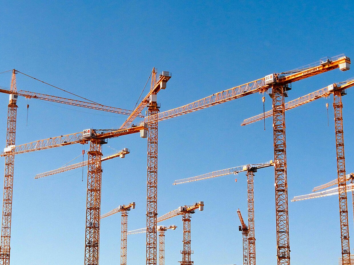 Viele Baukräne vor einem blauen Himmel