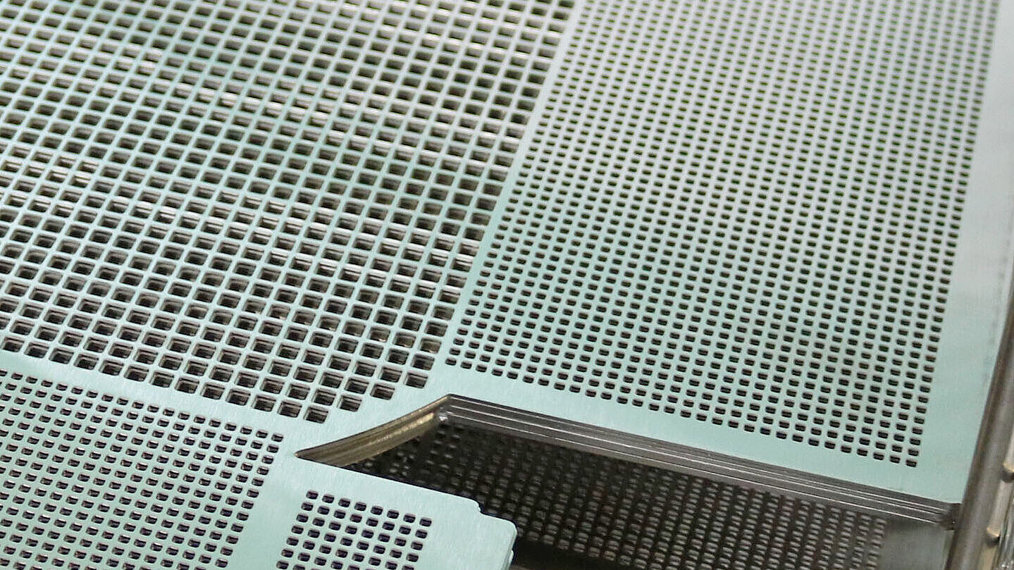 Metallgitter und -platten in einem industriellen Reinigungsbehälter.