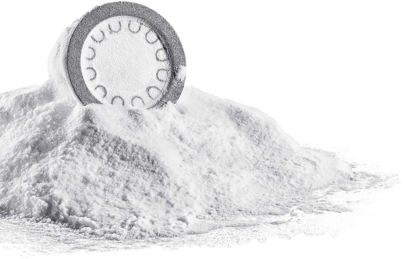 Ein weisses, ungereinigtes 3D-DruckBauteil, das auf einem Häufchen 3D-Druckpulver liegt